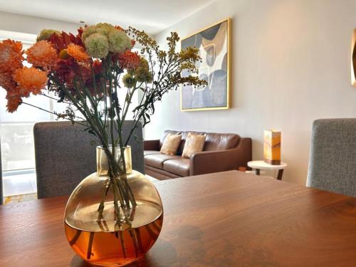 a vase filled with flowers sitting on a table at Cancún Bella & Vista Apartment in Cancún