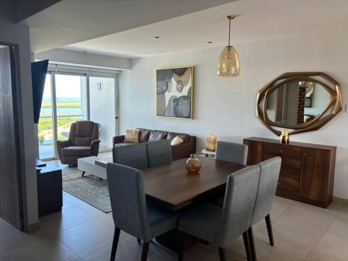 a living room with a dining room table and a mirror at Cancún Bella & Vista Apartment in Cancún
