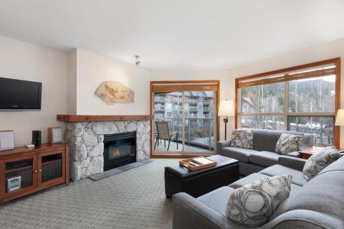 a living room with a couch and a fireplace at The Aspens by Whiski Jack in Whistler