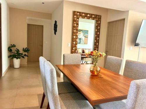 a dining room with a wooden table and chairs at Cancún Bella & Vista Apartment in Cancún