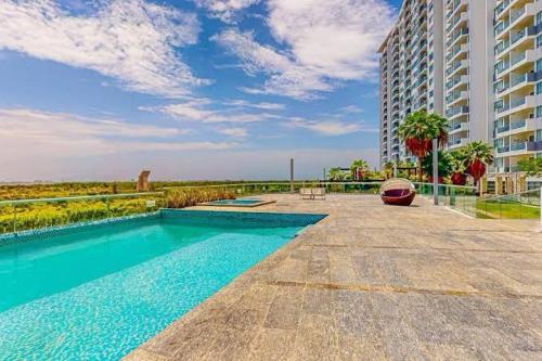 a swimming pool in front of a large building at Cancún Bella & Vista Apartment in Cancún