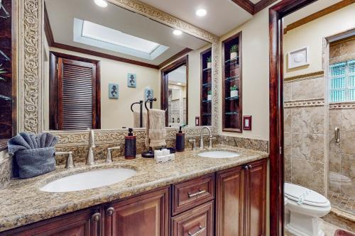 ein Badezimmer mit zwei Waschbecken und einer Toilette in der Unterkunft Coastal Paradise Getaway in Cape Coral