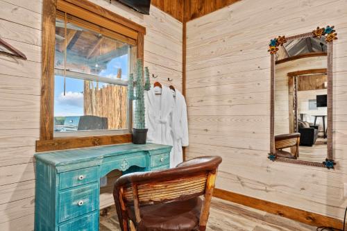 ein Holzzimmer mit einem blauen Schreibtisch und einem Spiegel in der Unterkunft Rockin' R - Shooting Star Cabin in Fredericksburg