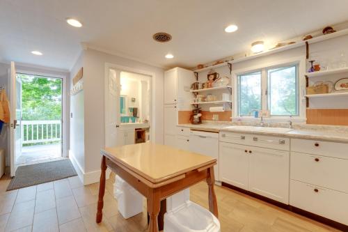 a kitchen with white cabinets and a wooden table at The Watson House about 16 Mi to Sebago Lake! in Cornish