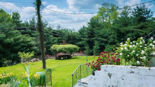 a garden with a park with a bench and flowers at Cozy Homeva Kensico WP in White Plains