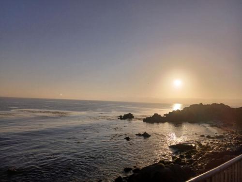 a view of the ocean with the sun setting at Carmel Comfort in Carmel