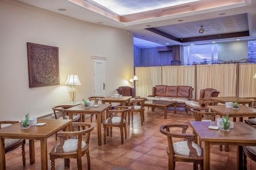 comedor con mesas y sillas de madera en Hotel Rosaleda Don Pedro, en Úbeda