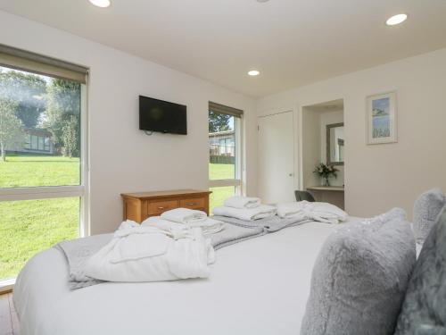 Un dormitorio con una cama blanca con toallas. en Willow, en Truro