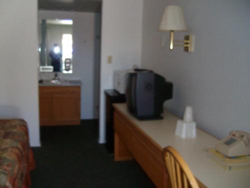 a hotel room with a bed and a tv on a table at Western Motel Ranchester in Ranchester