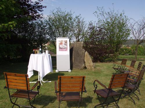 a table and chairs with a white table and a white table and chairs at Hotel Kaiseralm in Bischofsgrün