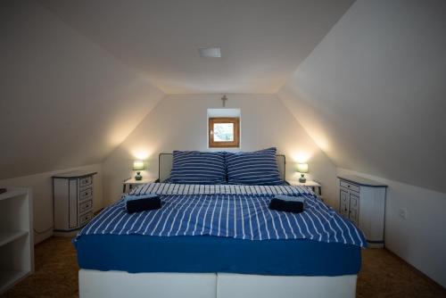 a bedroom with a blue and white bed in a attic at Barinka in Světec