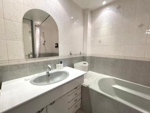 une salle de bain avec un lavabo, une baignoire et un miroir dans l'établissement Centre ville Troyes - Le Voltaire, à Troyes