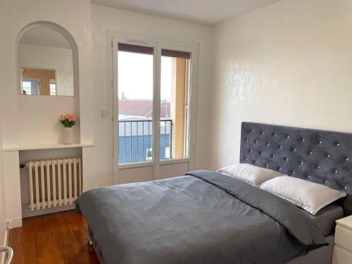 une chambre avec un grand lit et une fenêtre dans l'établissement Centre ville Troyes - Le Voltaire, à Troyes