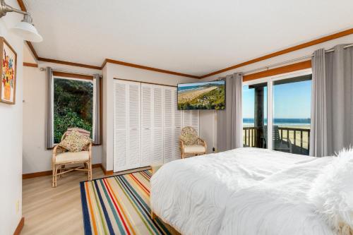 a bedroom with a bed and a view of the ocean at Little Creek Cove Beach Resort in Newport