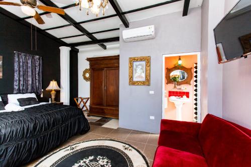 a bedroom with a bed and a living room at Garlands Del Rio Riverside Boutique Hotel in Puerto Vallarta