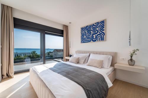 a bedroom with a large bed and a large window at Villa Mia with Heated Pool in Maslenica