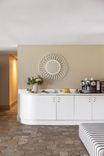 a kitchen with white cabinets and a mirror on the wall at Waves Byron Bay in Byron Bay