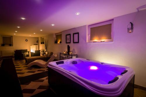 a room with a large purple tub in a living room at Penzion Raimund in Smokovce