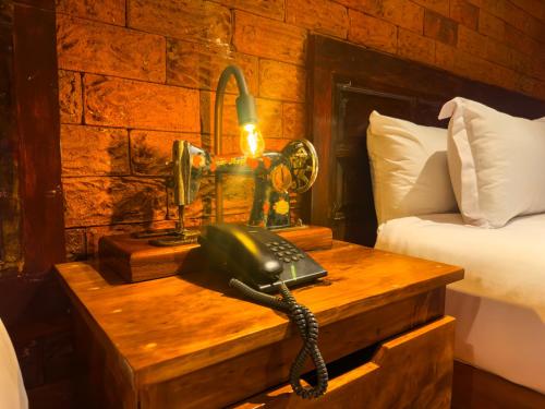 a telephone on a wooden table in a bedroom at Le Suisse Spa in Santa Lucía Milpas Altas