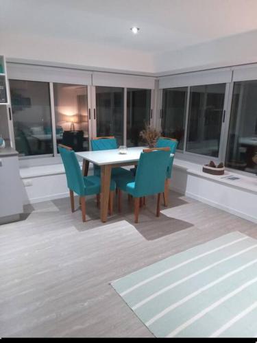 a dining room with a table and blue chairs at Apartamento nuevo in Punta del Este
