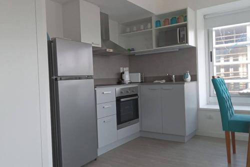 a kitchen with white cabinets and a refrigerator at Apartamento nuevo in Punta del Este