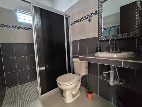 a bathroom with a toilet and a sink and a shower at Casa La Güerita in Progreso