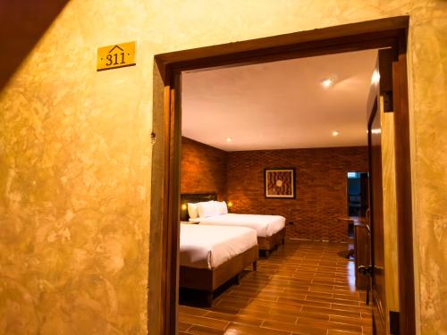 a hotel room with two beds and a doorway at Le Suisse Spa in Santa Lucía Milpas Altas