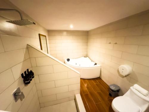 a bathroom with a sink and a toilet and a tub at Le Suisse Spa in Santa Lucía Milpas Altas