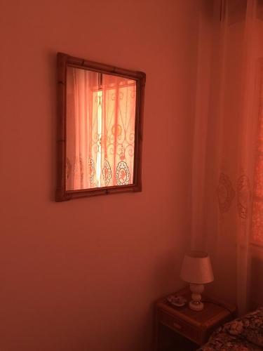 a bedroom with a window and a table with a lamp at Holiday Home Gionny & Mary in Taormina