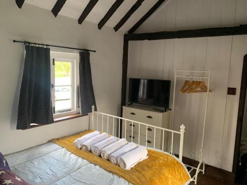 a bedroom with a bed with a television and towels at Quay Cottage in Sandwich, UK in Sandwich