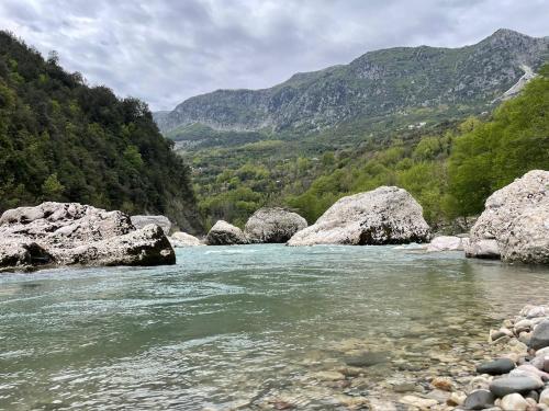 a river with rocks and mountains in the background at ToVouno in Plaka