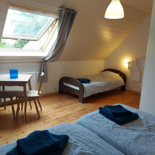 une chambre avec deux lits et une table et une fenêtre dans l'établissement Penty typique Kercab dans un ancien moulin, à Plomodiern