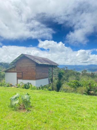 a building on top of a grassy hill at Hacienda Monteclaro in Turrialba