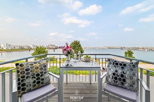 a table and chairs on a balcony with a view of the water at Ferienwohnung Harbour Side, App 7 Olpenitz in Olpenitz