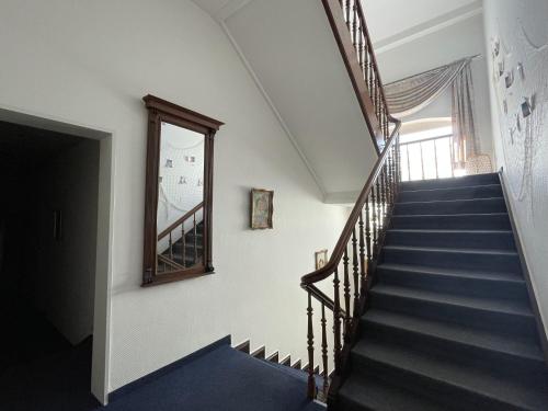 a staircase in a house with a mirror and a window at Villa Daheim in Borkum