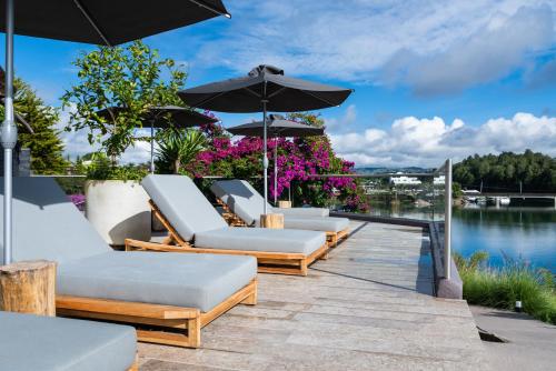 a row of lounge chairs and umbrellas on a dock at Tau House in Guatapé