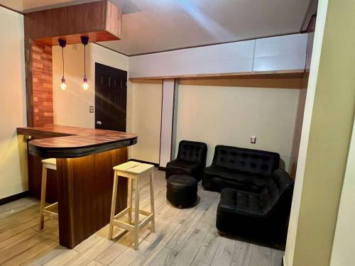 a living room with a bar and a couple of chairs at C&M Exclusive Private Rooms in Quetzaltenango