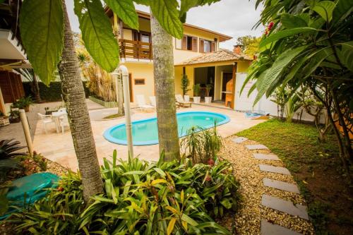 a backyard with a pool and a house at Hospedagem Tulipane - Praia do Campeche in Florianópolis