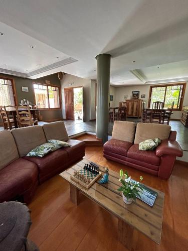 a living room with two couches and a table at Hospedagem Tulipane - Praia do Campeche in Florianópolis