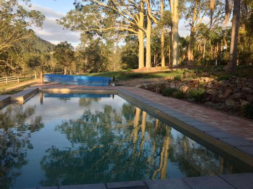 Charity Creek Retreat في Mount George: مسبح في حديقة فيها اشجار في الخلفية