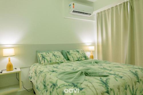 a bedroom with a bed with a green comforter at In Mare Bali Resort Beira Mar by Qavi - 109 in Parnamirim