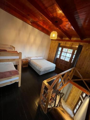 an attic room with two beds and a staircase at Hospedaje El Tucan in Puerto Iguazú