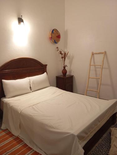 a bedroom with a large bed with a wooden headboard at Dar ziane 1 in El Jadida