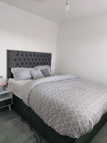 ラグビーにあるModern Entire 3-Bedroom House in Rugbyの白い壁のベッドルームのベッド1台