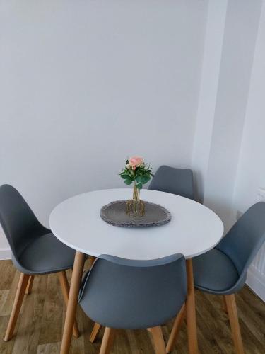 ラグビーにあるModern Entire 3-Bedroom House in Rugbyの白いテーブルと青い椅子、花瓶