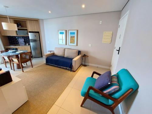 ein Wohnzimmer mit einem Sofa und einem blauen Stuhl in der Unterkunft BookSantos - Estanconfor 1604 Vista Mar in Santos