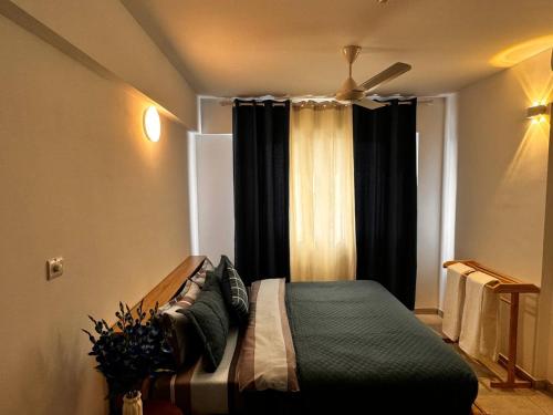 a bedroom with a bed with a ceiling fan at Lilys By Dhalhey's in Hulhumale