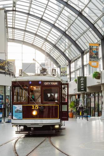 a trolley car in a building with a glass ceiling at Quest Cathedral Junction Serviced Apartments in Christchurch