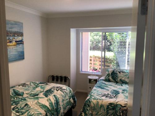 a bedroom with a bed and a window at Bethlehem Garden Retreat in Tauranga