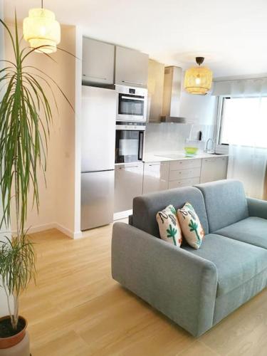 un salon avec un canapé bleu et une cuisine dans l'établissement Chez L'Hadriana, 2x AC clim Wi-Fi,newly renovated, à Nice